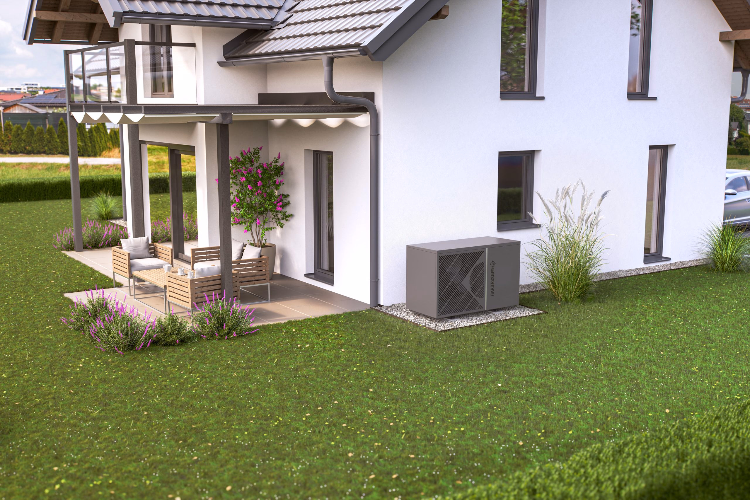 Außenansicht einer Hargassner Luft-Wasser-Wärmepumpe neben einem Einfamilienhaus mit Terrasse