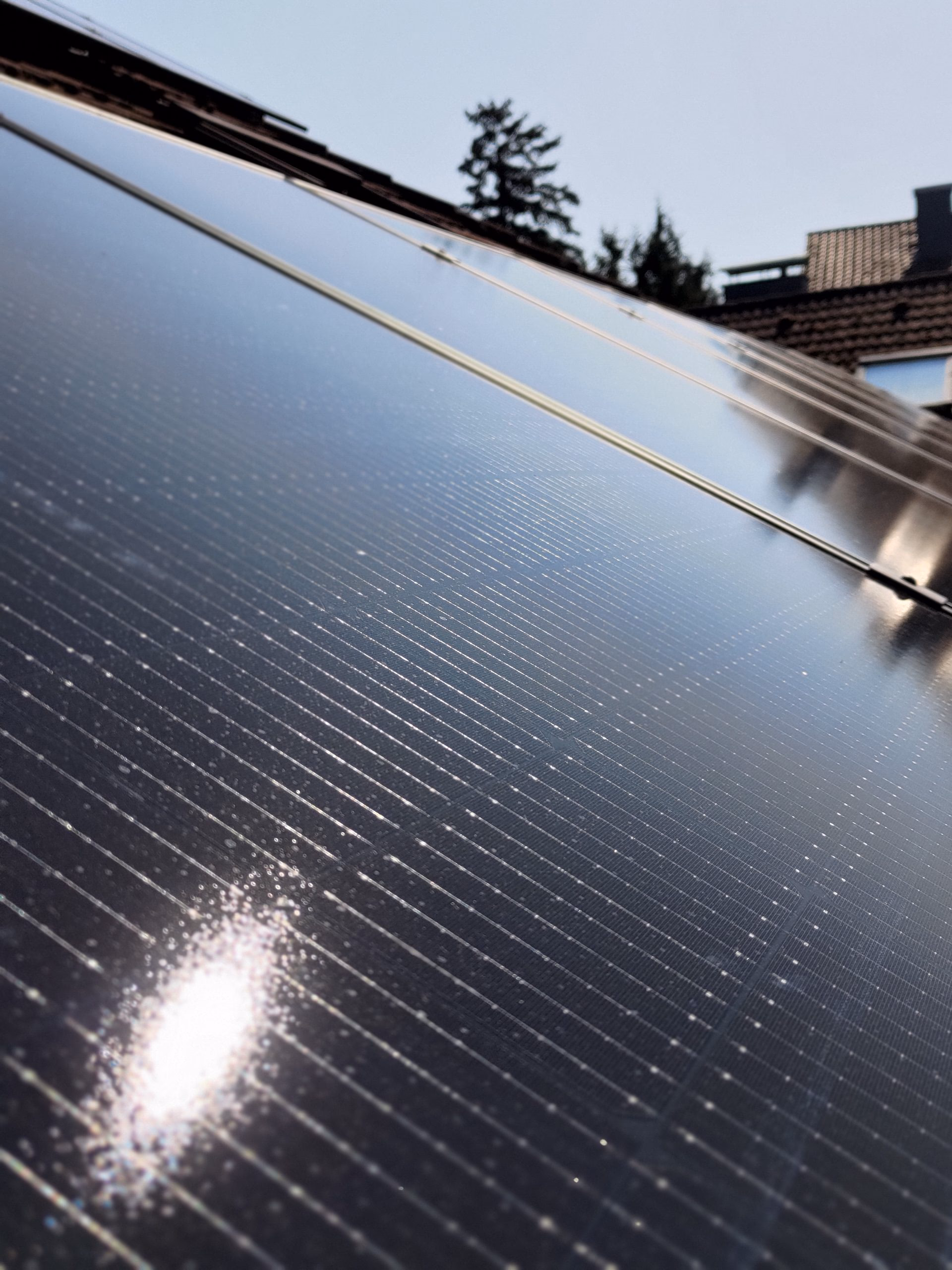 Nahaufnahme monokristalliner Photovoltaik-Module auf einem geneigten Hausdach